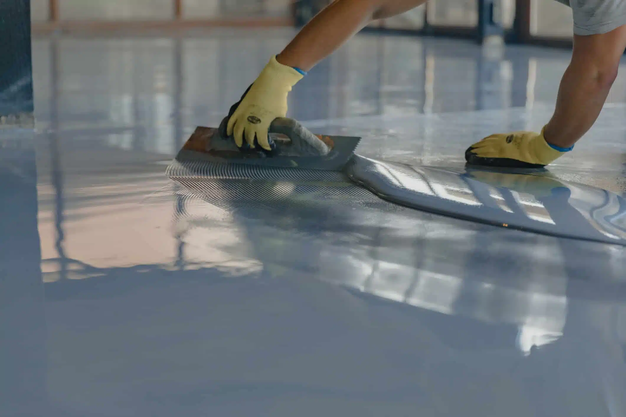 Epoxy floor coating being applied to warehouse floor